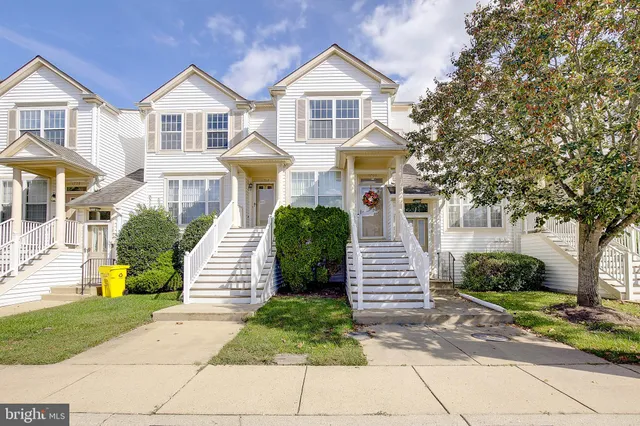 a front view of a house with a yard and potted plants