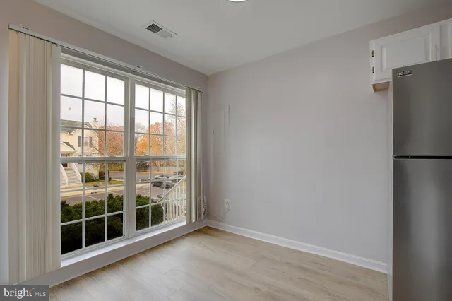 a view of empty room with wooden floor and floor to ceiling window