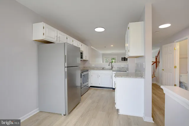 a kitchen with cabinets a refrigerator and a stove