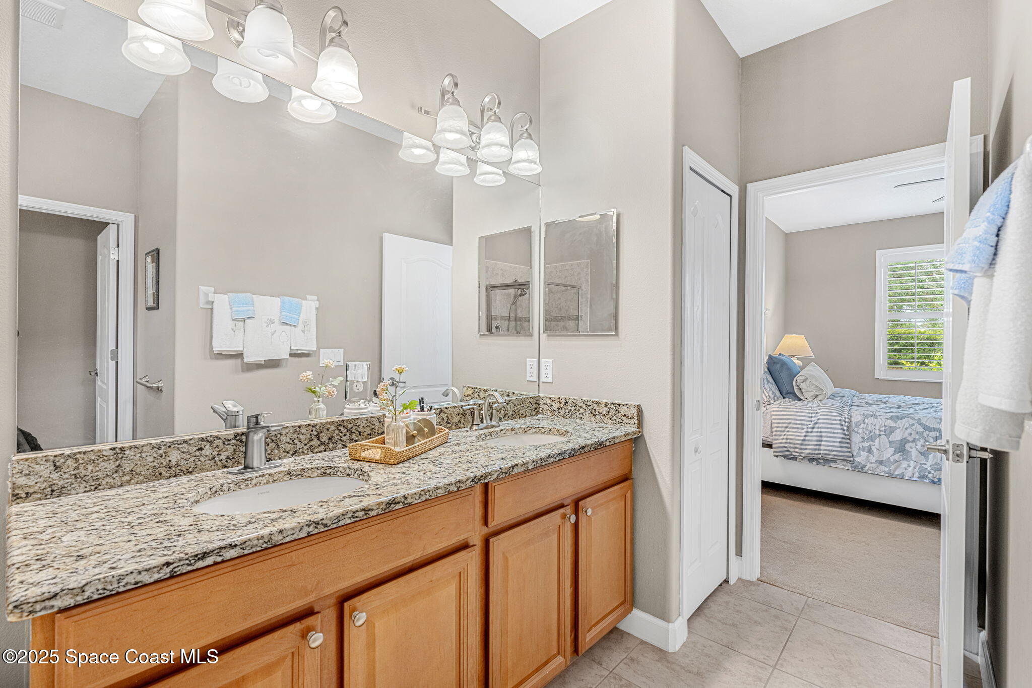 6741 Ringold Street Melbourne, FL 32940 - Photo 17 of 45 a en suite bathroom with a granite countertop double vanity and a mirror