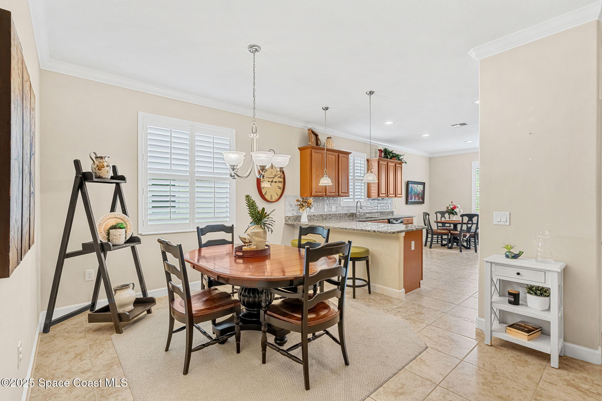 6741 Ringold Street Melbourne, FL 32940 - Photo 6 of 45 a view of a dining room and livingroom with furniture wooden floor a chandelier