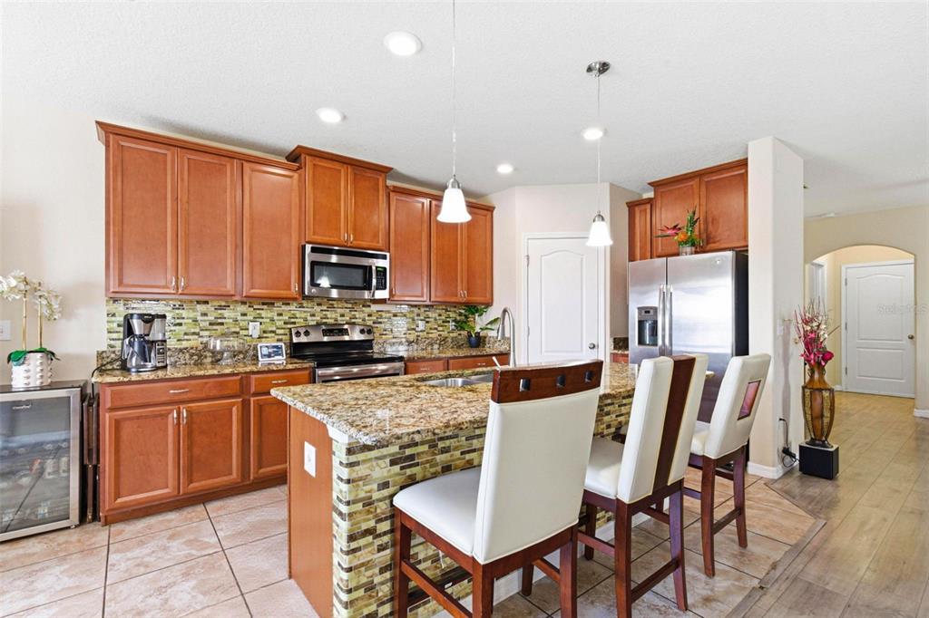 10135 Newminster Loop Ruskin, FL 33573 - Photo 12 of 35 a kitchen with granite countertop a stove top oven dining table and chairs