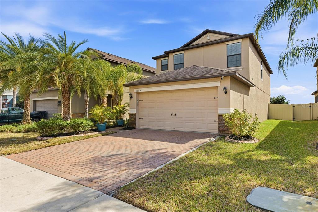 10135 Newminster Loop Ruskin, FL 33573 - Photo 2 of 35 a front view of a house with a yard and garage