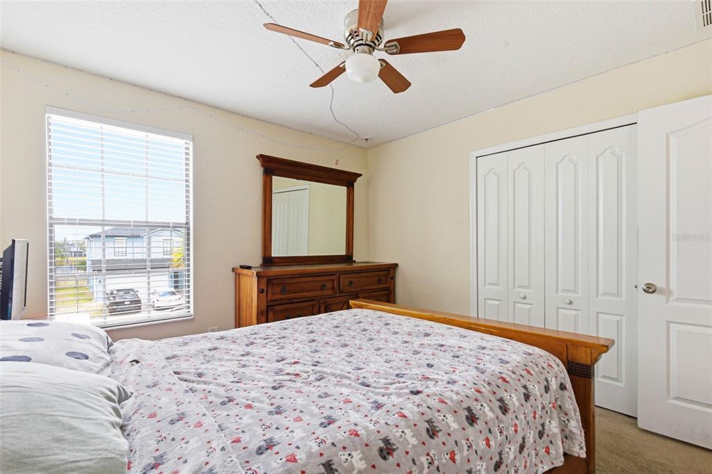 10135 Newminster Loop Ruskin, FL 33573 - Photo 25 of 35 a bedroom that has a bed and a chandelier