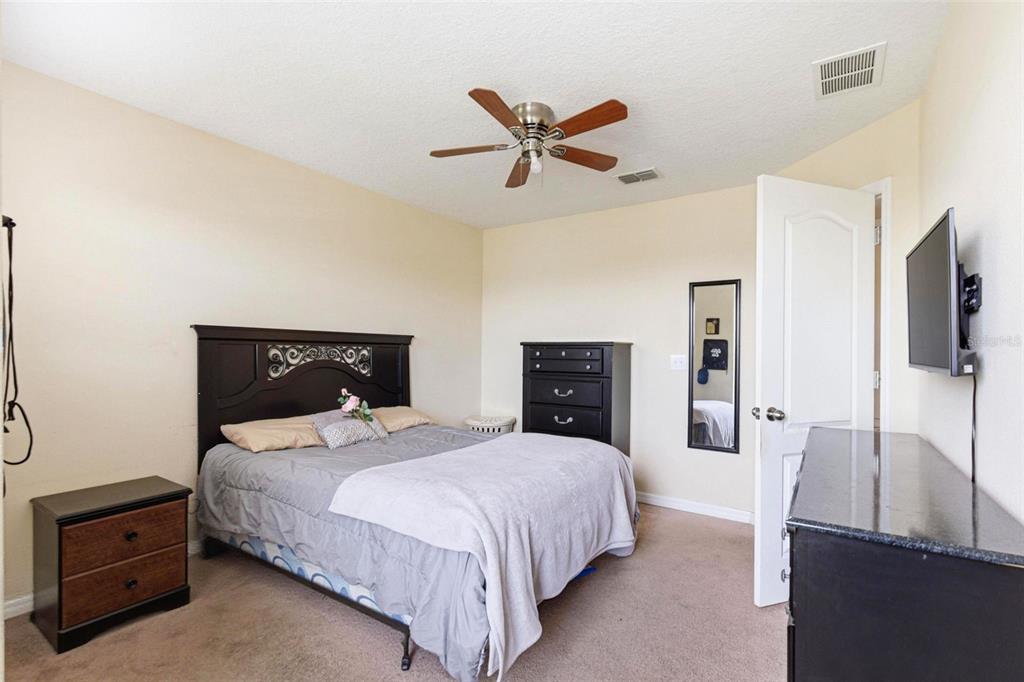 10135 Newminster Loop Ruskin, FL 33573 - Photo 27 of 35 a bedroom with a bed and dresser