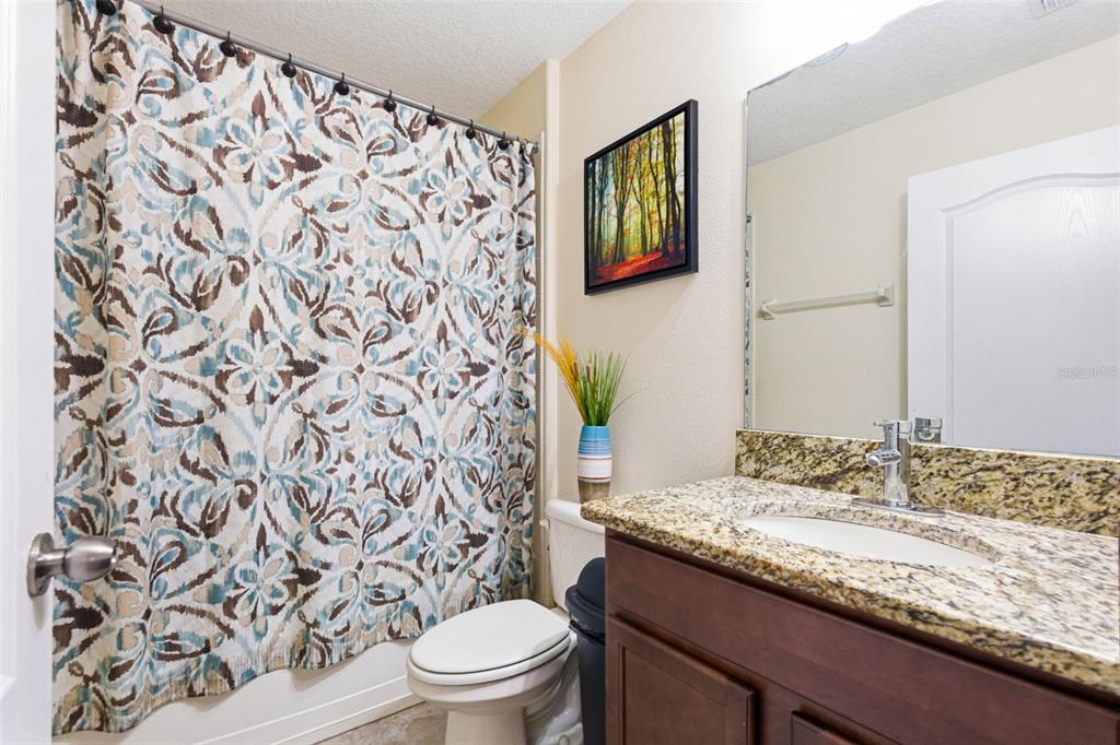 10135 Newminster Loop Ruskin, FL 33573 - Photo 28 of 35 a bathroom with a granite countertop sink and a toilet
