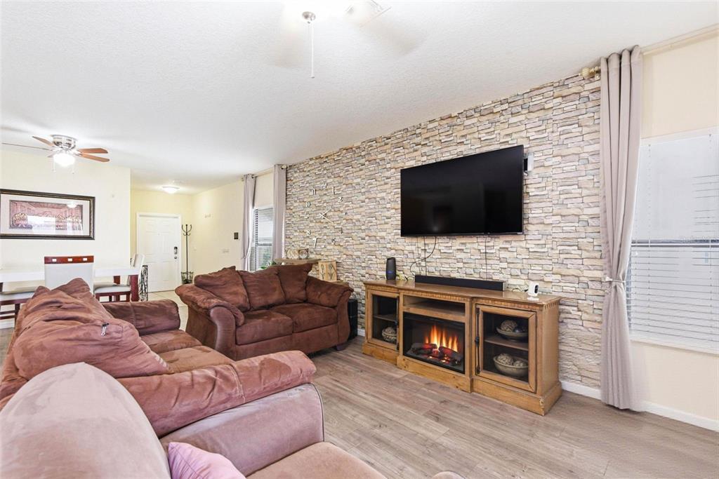 10135 Newminster Loop Ruskin, FL 33573 - Photo 6 of 35 a living room with fireplace furniture and a flat screen tv