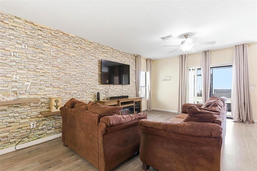 10135 Newminster Loop Ruskin, FL 33573 - Photo 8 of 35 a living room with furniture and a flat screen tv