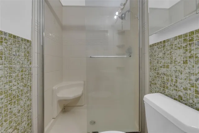 a bathroom with a toilet and a shower