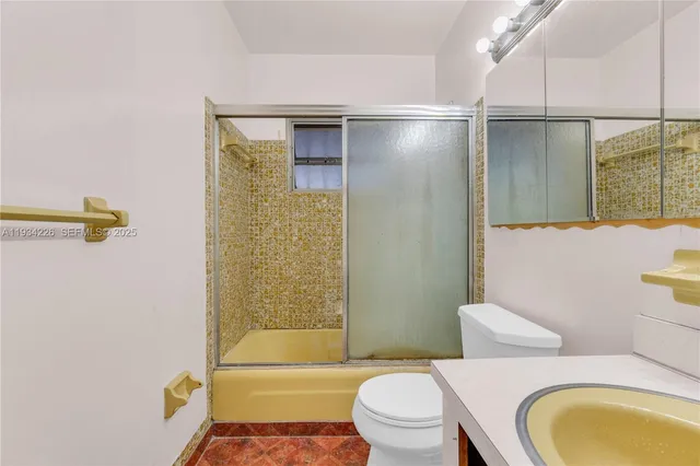 a bathroom with a granite countertop bathtub shower sink vanity and toilet
