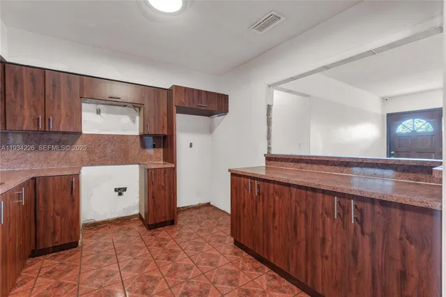 a view of a hallway with entryway wooden floor and cabinet