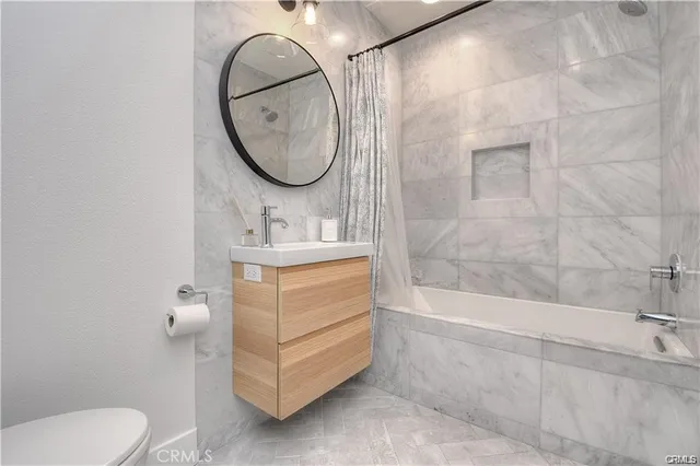 a bathroom with a sink a toilet and a mirror