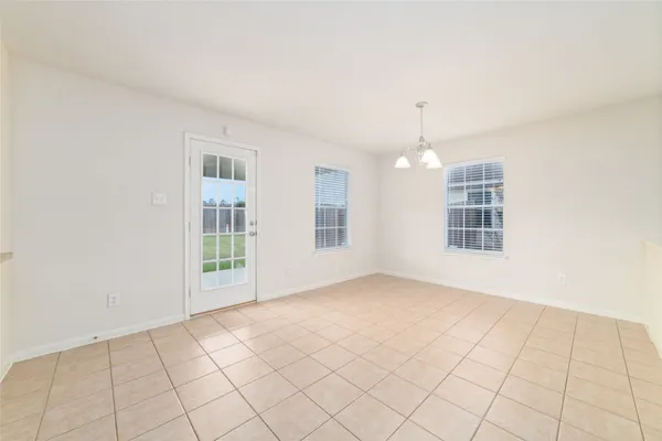 an empty room with windows and chandelier