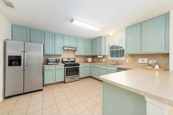 a kitchen with granite countertop a refrigerator sink and cabinets