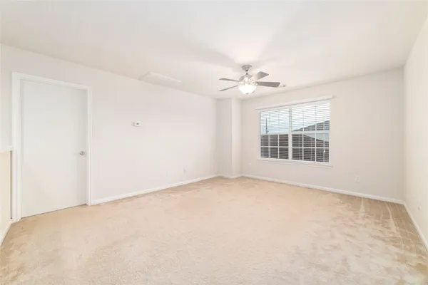 an empty room with windows and chandelier fan