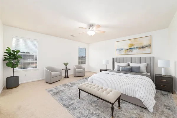 a bedroom with a large bed couch and a potted plant