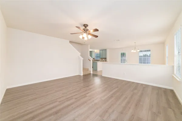 a view of a kitchen with wooden floor and a ceiling fan