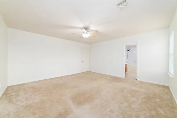 an empty room with a ceiling fan and a window