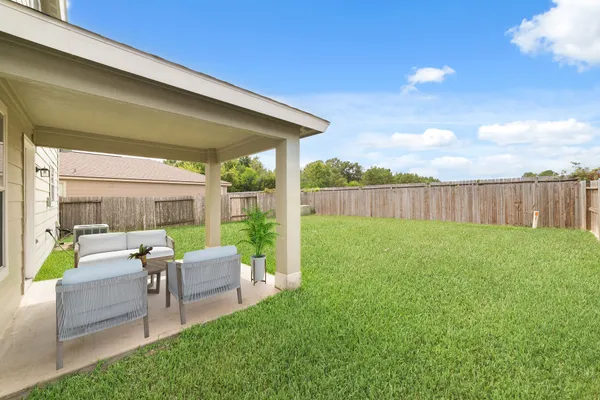 a view of backyard with seating area and green space