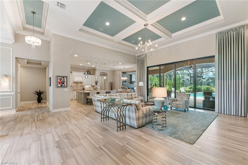 11974 Maidstone Court Naples, FL 34120 - Photo 19 of 45 Great Room with a chandelier, crown molding, coffered ceiling, a towering ceiling, and Tray ceiling