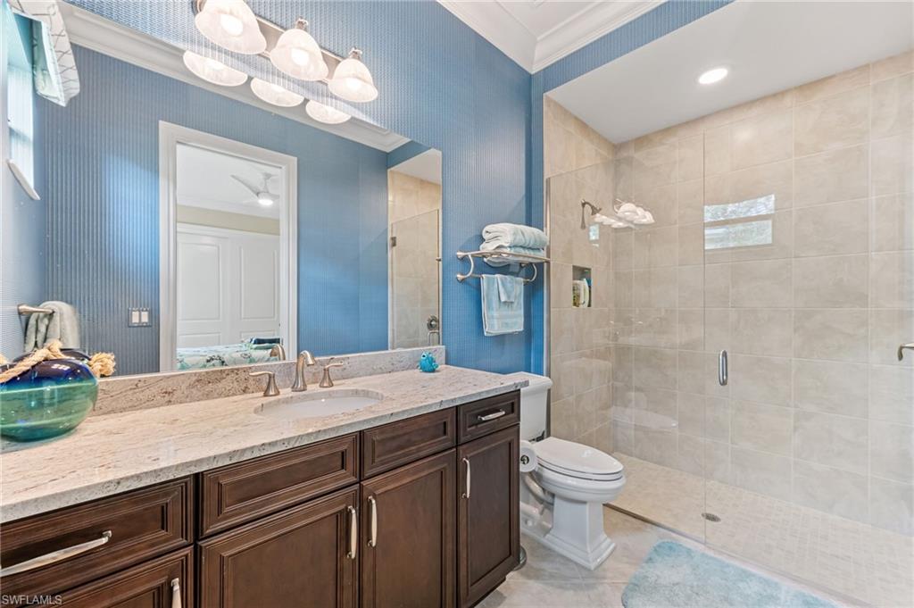 11974 Maidstone Court Naples, FL 34120 - Photo 22 of 45 Full bathroom featuring a shower stall, crown molding, vanity, and tile patterned floors