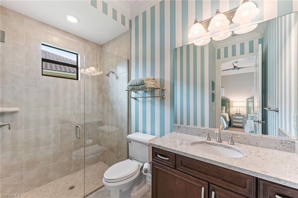 11974 Maidstone Court Naples, FL 34120 - Photo 25 of 45 Bathroom featuring a shower stall, vanity, ornamental molding, and ceiling fan