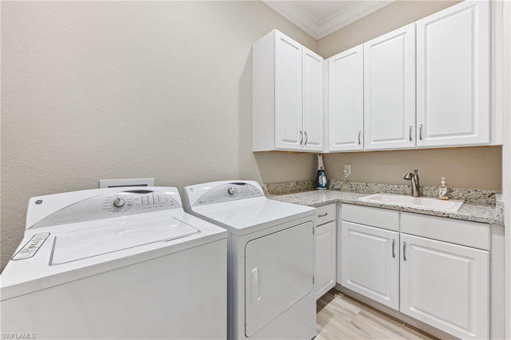 11974 Maidstone Court Naples, FL 34120 - Photo 38 of 45 Laundry area with ornamental molding, cabinet space, separate washer and dryer, and light wood finished floors