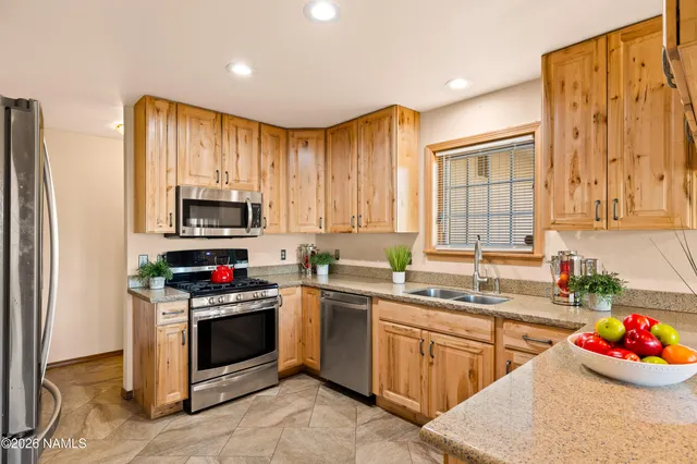 a kitchen with stainless steel appliances kitchen island granite countertop a sink dishwasher stove and cabinets