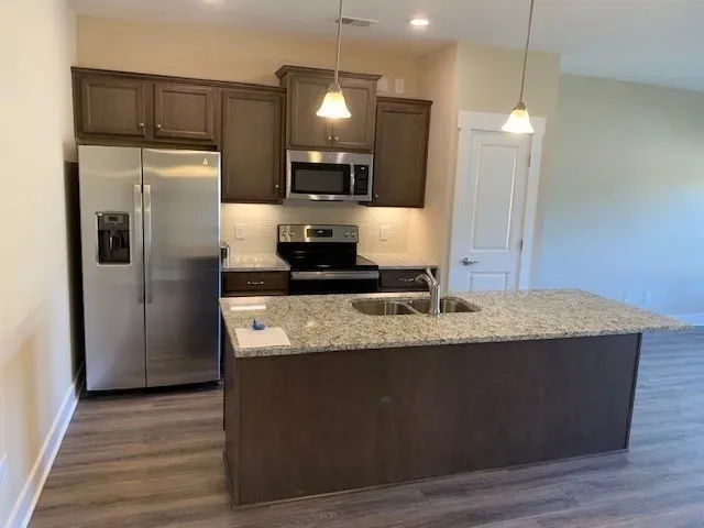 a kitchen with kitchen island counter space a sink appliances and cabinets