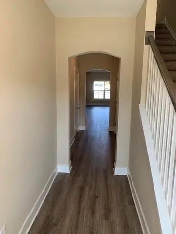 a view of a hallway with wooden floor and staircase