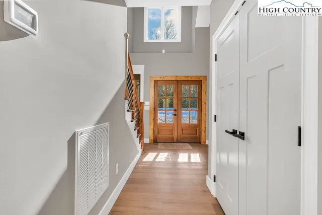 a view of a hallway with wooden floor and staircase