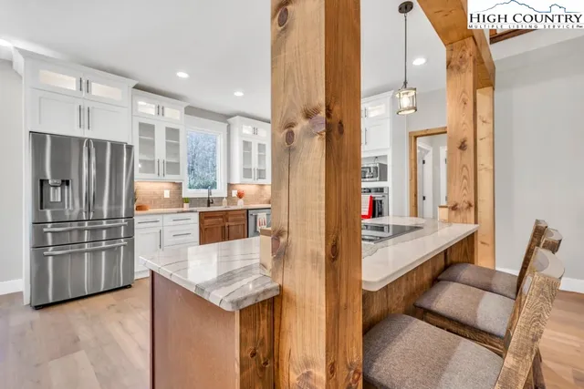 a kitchen with stainless steel appliances kitchen island granite countertop a refrigerator and a stove