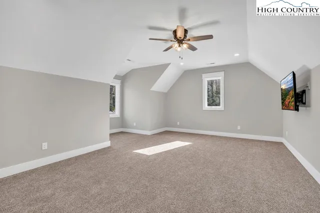 an empty room with fan and windows