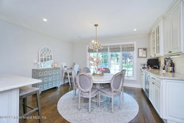 a dining room with furniture a chandelier and wooden floor