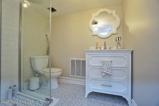a bathroom with a toilet a sink and mirror