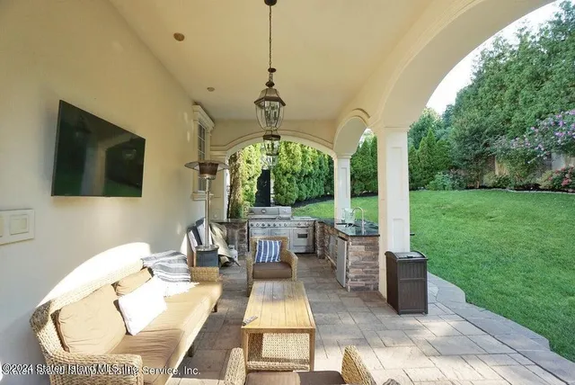 a living room with patio furniture and a garden