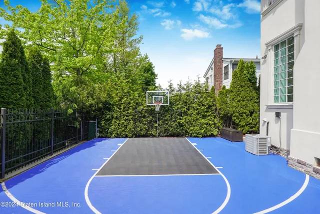 a view of a backyard with table and chairs potted plants and floor to ceiling window