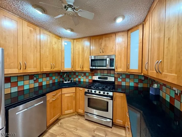 a kitchen with stainless steel appliances a stove sink microwave and cabinets
