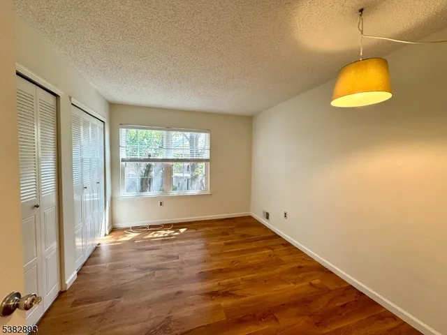 an empty room with a window and wooden floor