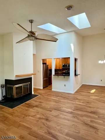 a view of a livingroom with a flat screen tv wooden floor and a ceiling fan