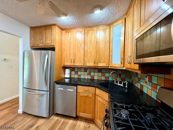 a kitchen with stainless steel appliances granite countertop a refrigerator and a sink