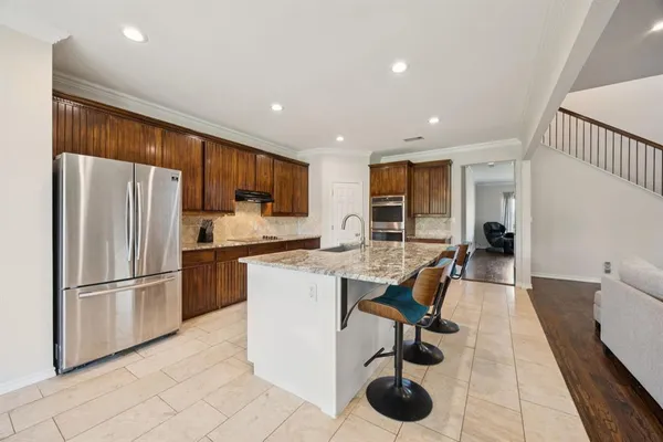 a kitchen with stainless steel appliances granite countertop a refrigerator and a sink