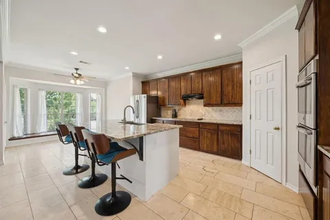 a kitchen with stainless steel appliances granite countertop a stove top oven a sink refrigerator and cabinets