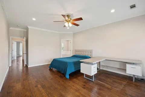 a living room with a bed furniture and a wooden floor