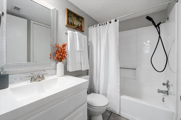a bathroom with a sink vanity granite tub and shower