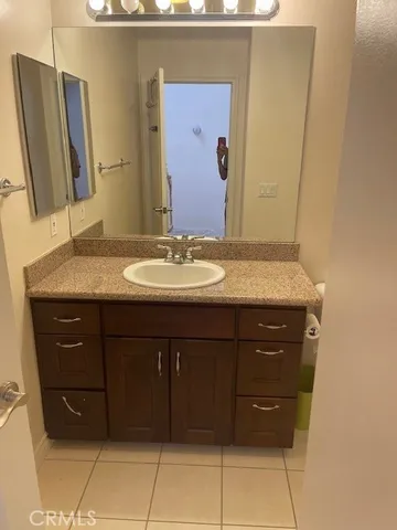 a bathroom with a granite countertop sink and a mirror