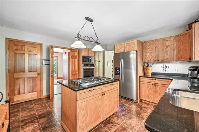 a kitchen with stainless steel appliances granite countertop a stove refrigerator and cabinets