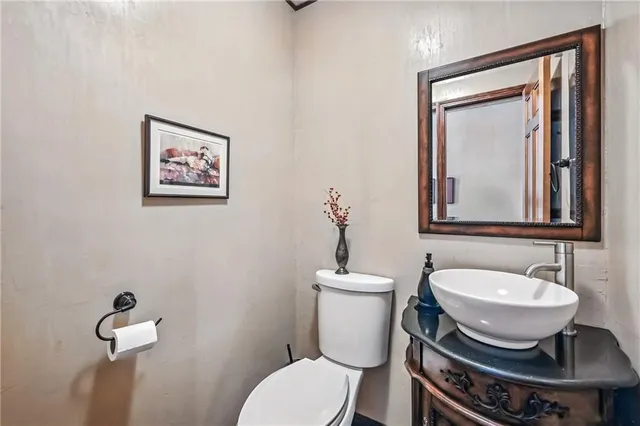 a bathroom with a toilet a sink and mirror
