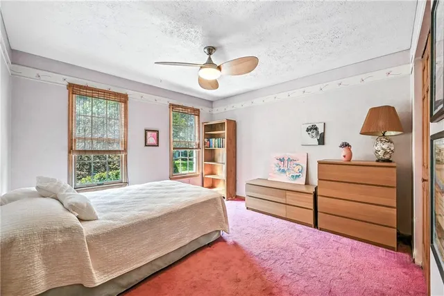 a view of a brick house with a small yard and plants