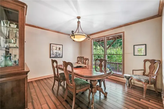 a dining room with furniture a chandelier and wooden floor